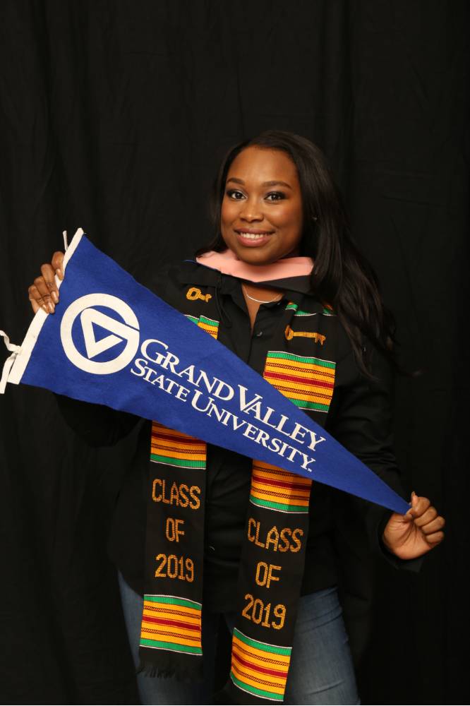 GradFest attendee holding up gvsu flag for a picture
